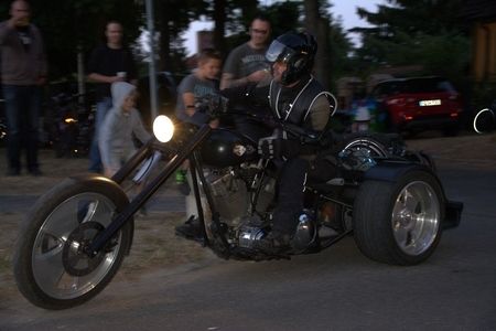 Ein Biker mit Helm auf einem dunklen Motorrad